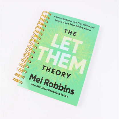 Green notebook with gold spiral binding titled 'The Let Them Theory' by Mel Robbins on a white background