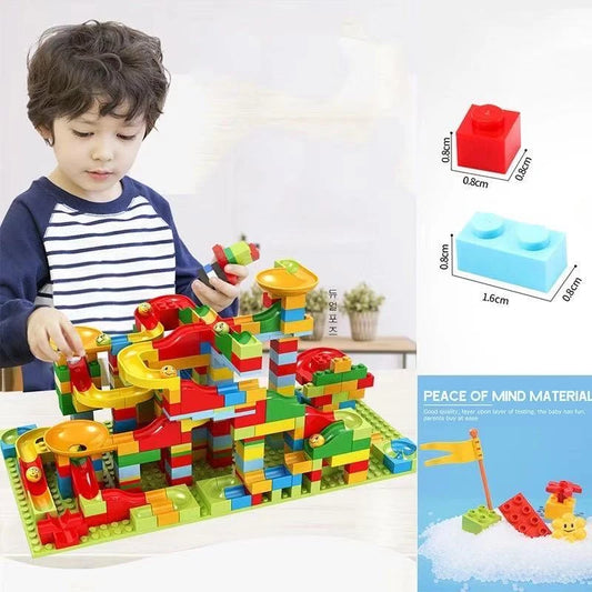 Child playing with a colorful marble run toy set on a white background
