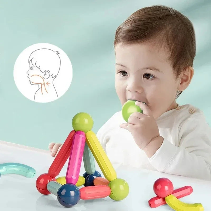 Child playing with colorful baby teething toys on a light blue background